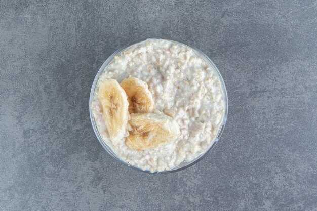 Un plato de cristal de gachas de avena con rodajas de plátano.