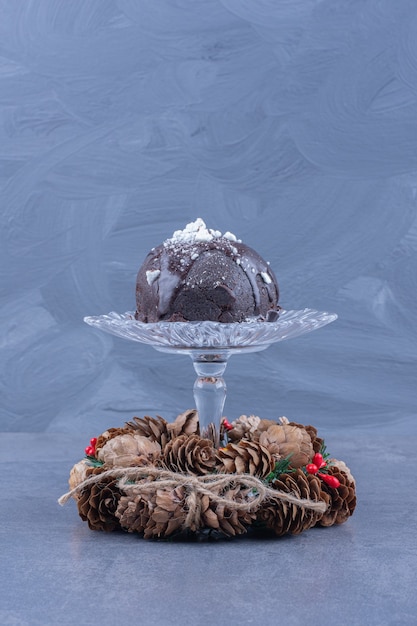 Un plato de cristal con tarta de chocolate y piñas.