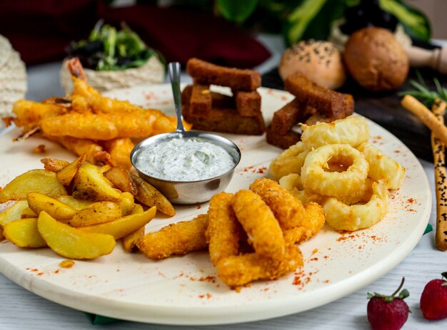 plato de crocante de calamares fritos crujientes, gambas, tomate y pollo y salsa