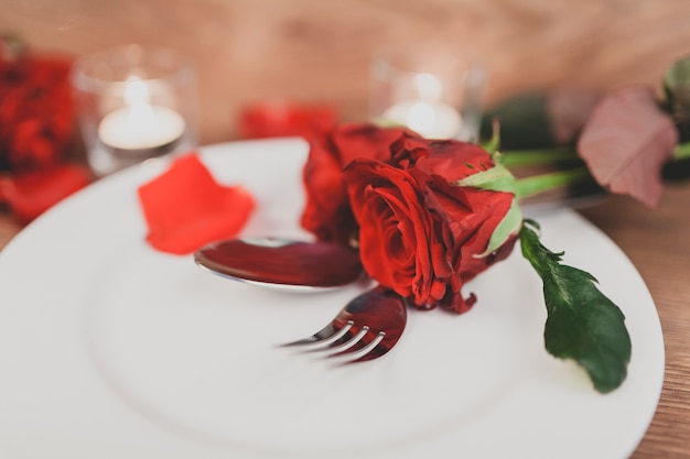 Plato con cubiertos y rosas de cerca