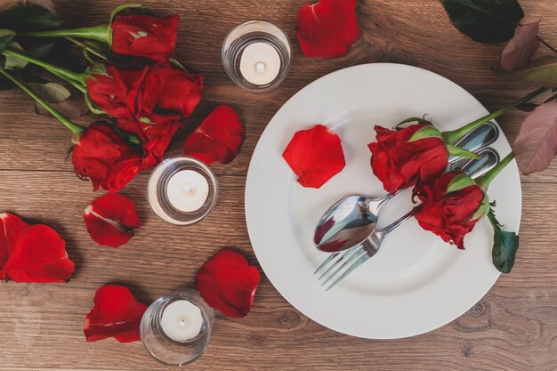 Plato con cubiertos y rosas