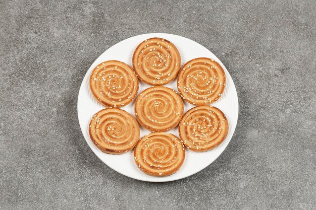 Plato de deliciosas galletas redondas sobre superficie de mármol