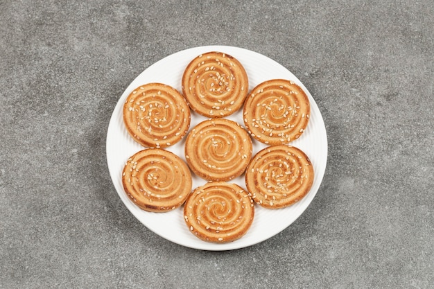 Plato de deliciosas galletas redondas sobre superficie de mármol