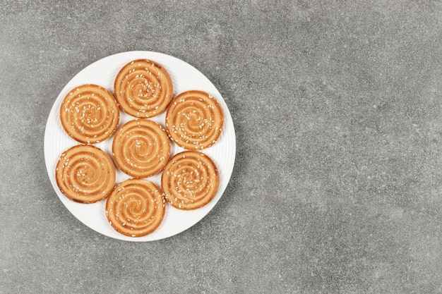 Plato de deliciosas galletas redondas sobre superficie de mármol