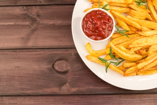 Plato con deliciosas papas fritas y salsa de tomate