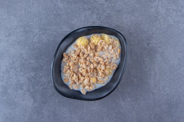 Un plato de delicioso muesli, sobre la mesa azul.