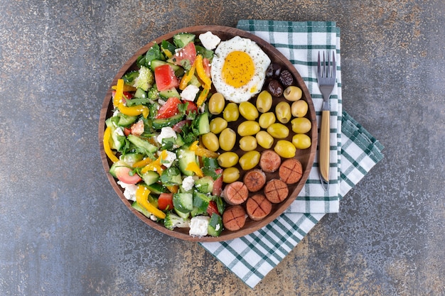 Plato de desayuno con huevos fritos y ensalada de verduras