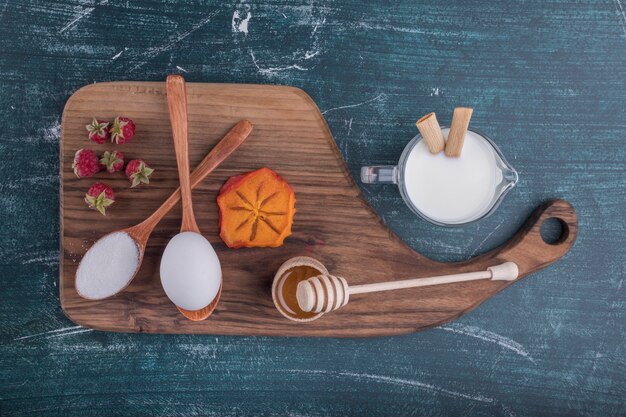 Plato de desayuno con ingredientes sobre una tabla de madera, vista superior