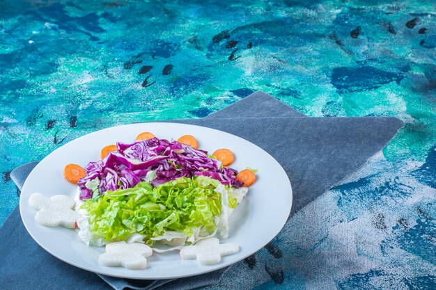 Un plato de diversas verduras frescas sobre un trozo de tela