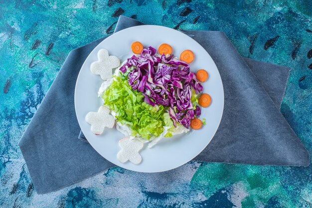 Un plato de diversas verduras frescas sobre un trozo de tela