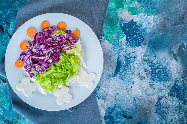 Un plato de diversas verduras frescas sobre un trozo de tela