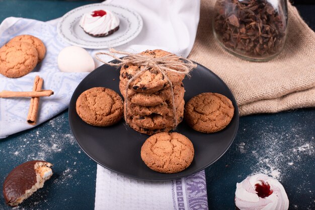 Plato de dulces y dos pasteles y galletas con canela