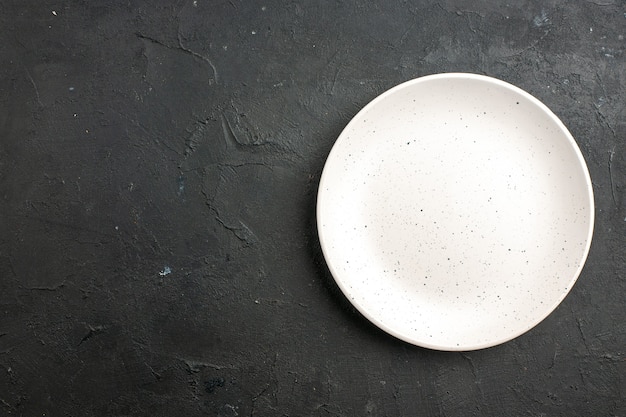 Plato de ensalada blanco vista superior en mesa oscura con espacio libre