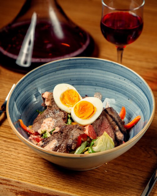 Un plato de ensalada de carne con lechuga pimientos salsa de pomelo vertical foto