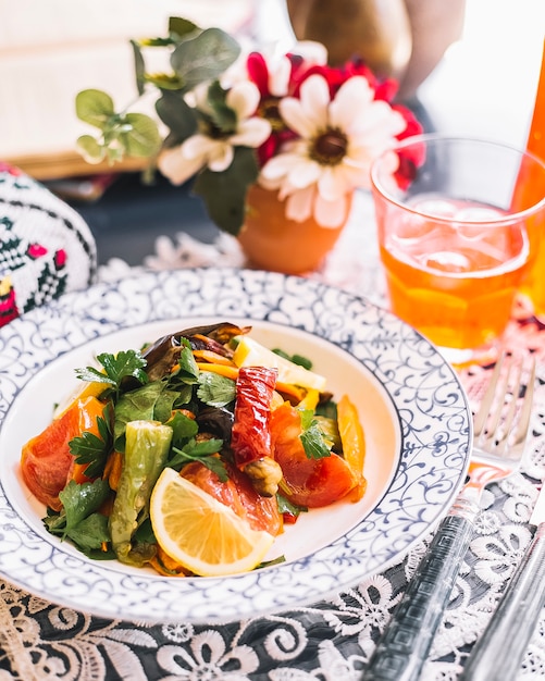 Foto gratuita un plato de ensalada de vegetales salteados con pimientos berenjena tomate hierbas y limón