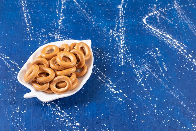 Plato en forma de hoja de pretzels redondos salados colocados en un plato colorido.