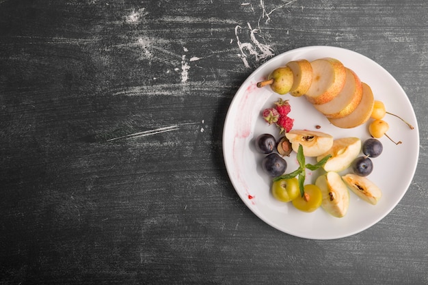 Plato de fruta blanca aislado sobre fondo negro a la derecha