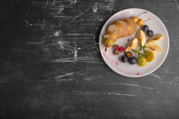 Plato de fruta blanca aislado sobre fondo negro