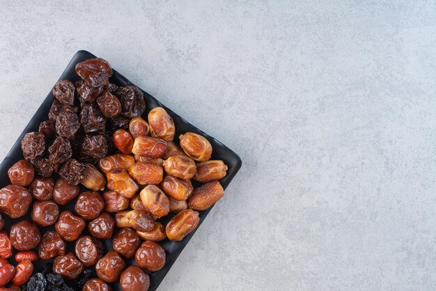 Plato de frutos secos aislado sobre fondo de hormigón.