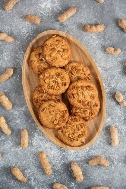 Plato de galletas caseras con maní orgánico sobre mesa de mármol.