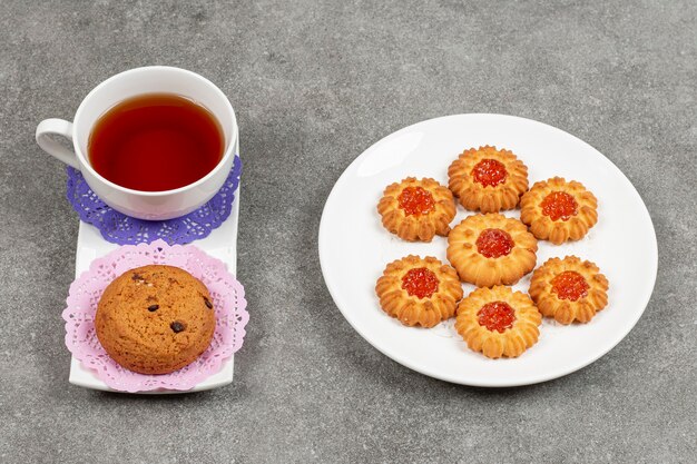 Plato de galletas de gelatina con taza de té y galleta con chip