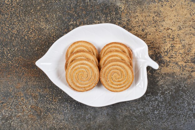 Plato de galletas de semillas de sésamo sobre mesa de mármol.