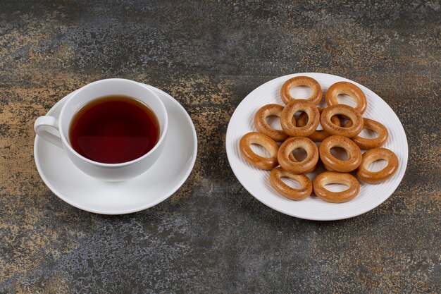 Plato de galletas y taza de té en mármol.