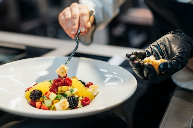 Foto gratuita plato de guarnición de chef femenina