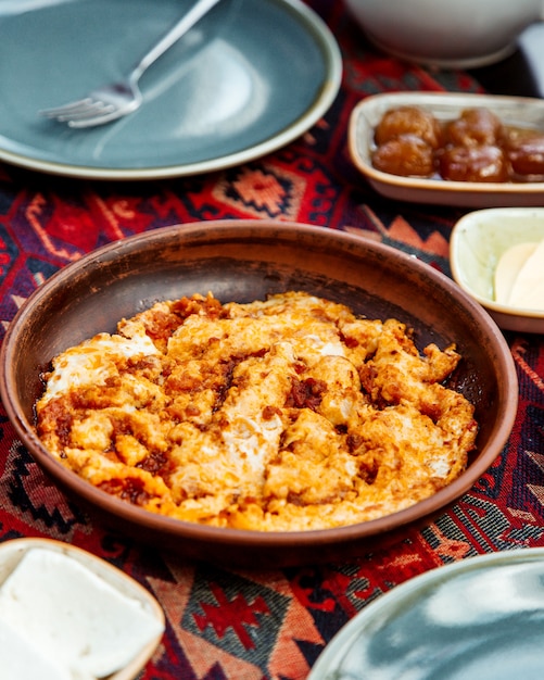 Plato de huevo y tomate en cazuela de barro servido para el desayuno