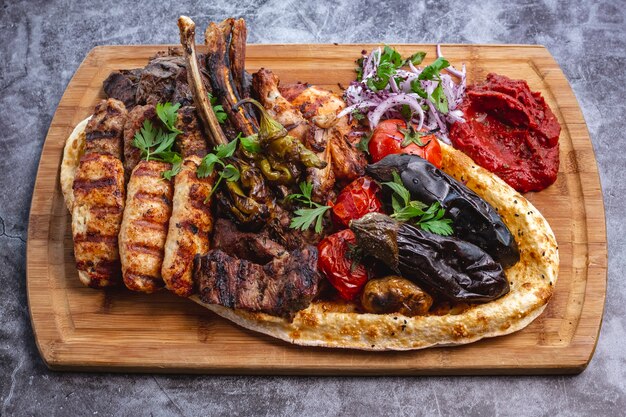 Plato de kebab con cordero y pollo lula y kebabs tikka verduras a la parrilla con ensalada de cebolla roja