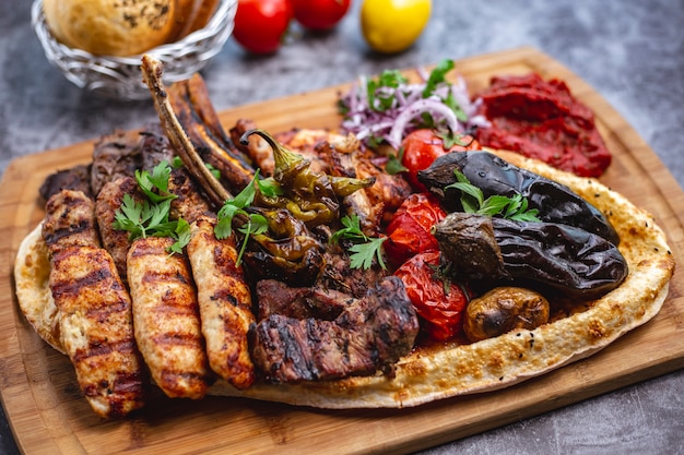 Plato de kebab con cordero y pollo lula y kebabs tikka verduras a la parrilla con ensalada de cebolla roja