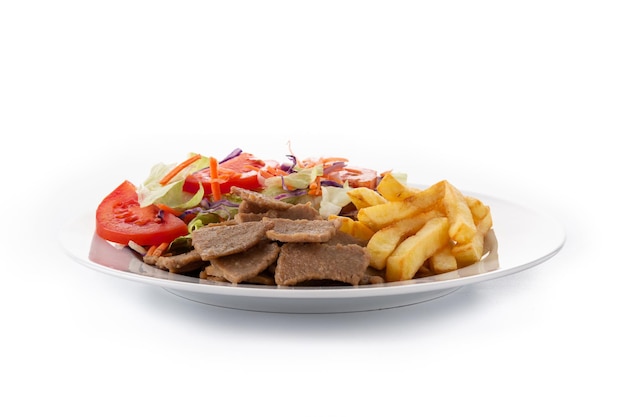 Plato de kebab, verduras y patatas fritas aislado sobre fondo blanco.