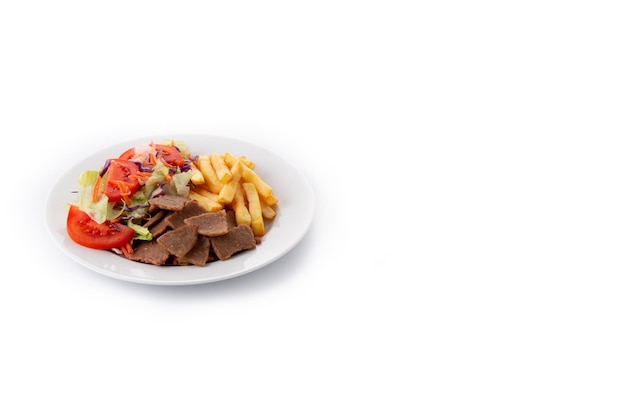 Plato de kebab, verduras y patatas fritas aislado sobre fondo blanco.