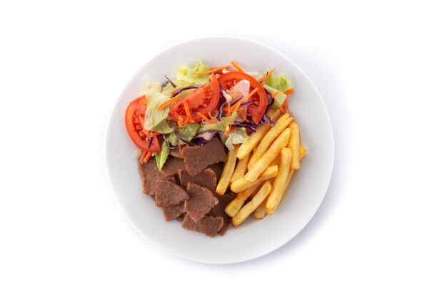 Plato de kebab, verduras y patatas fritas aislado sobre fondo blanco.