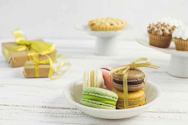 Foto gratuita plato de macarons con dulces borrosos detrás