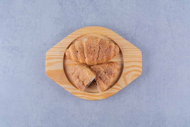 Un plato de madera de croissants con delicioso chocolate.