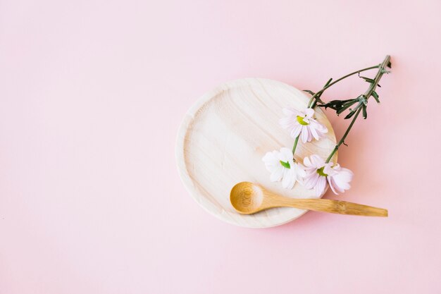 Plato de madera con cuchara y flor
