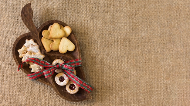 Foto gratuita plato de madera con diferentes galletas.