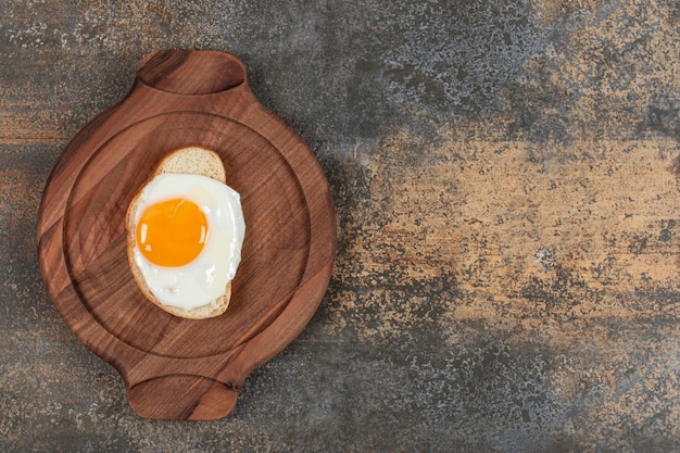 Foto gratuita un plato de madera de huevo en la rebanada de pan blanco.