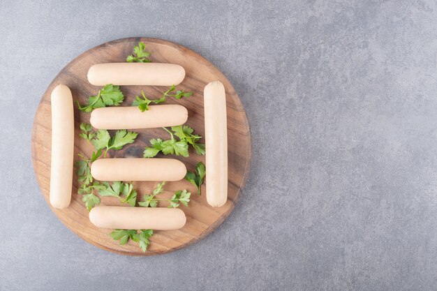 Un plato de madera de salchichas hervidas con perejil