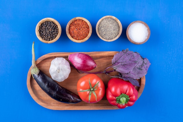 Foto gratuita plato de madera de verduras frescas maduras con diversas especias