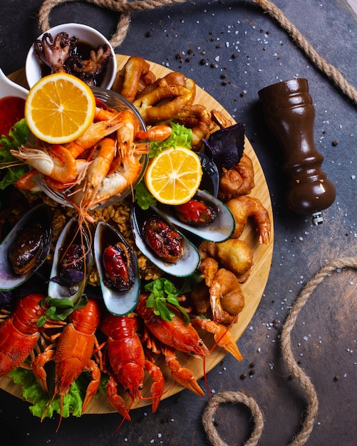 Plato de mariscos con gambas, mejillones, langostas servidas con limón