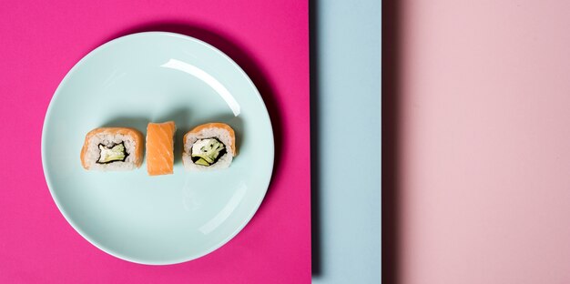 Plato minimalista con rollos de sushi y capas de fondo.