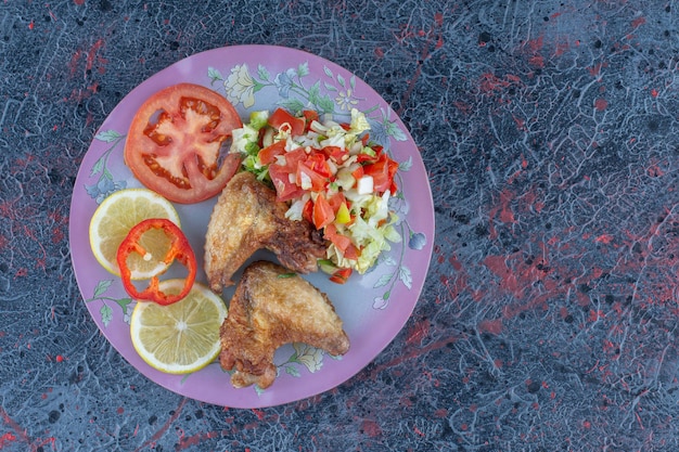 Un plato morado de carne de pollo con ensalada de verduras.