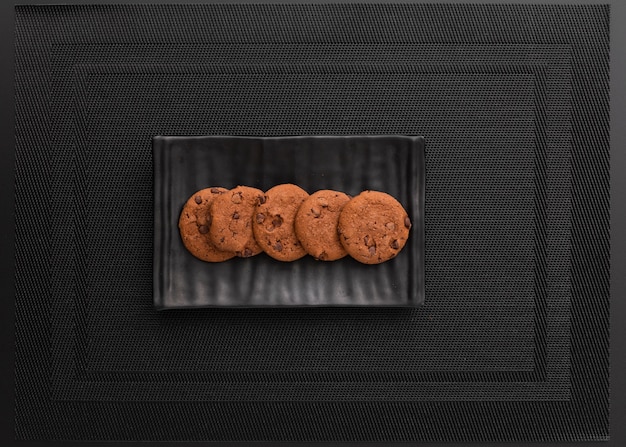 Plato oscuro con galletas en un paño oscuro