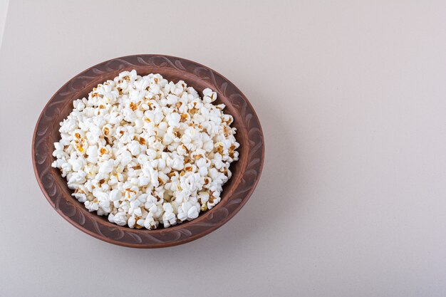 Plato de palomitas de maíz saladas para noche de cine sobre fondo blanco. Foto de alta calidad