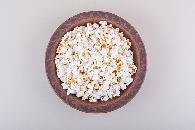 Plato de palomitas de maíz saladas para la noche de cine sobre fondo blanco. Foto de alta calidad