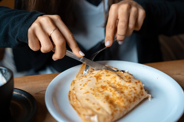 En un plato panqueque con requesón y cerezas.