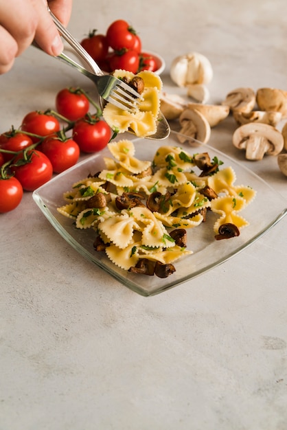 Foto gratuita plato de pasta con champiñones y tomates