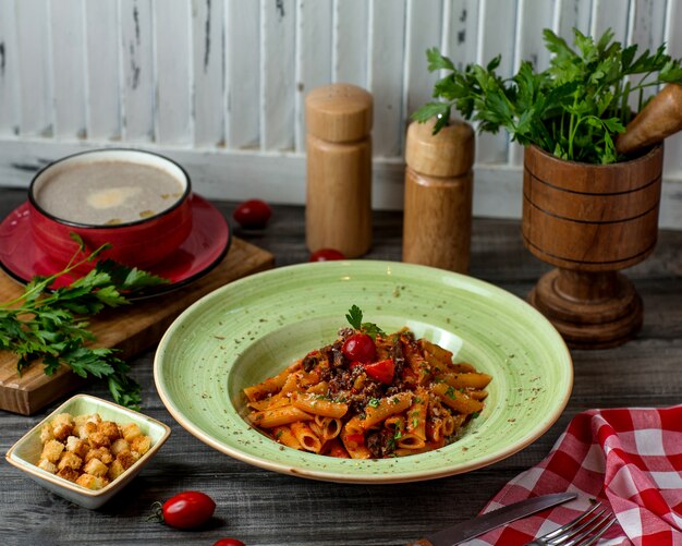 Plato de pasta Penne con salsa de tomate, parmesano y hierbas